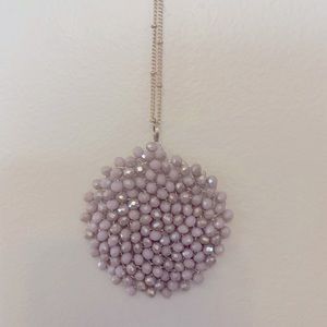 Gold necklace with pink embellishment.